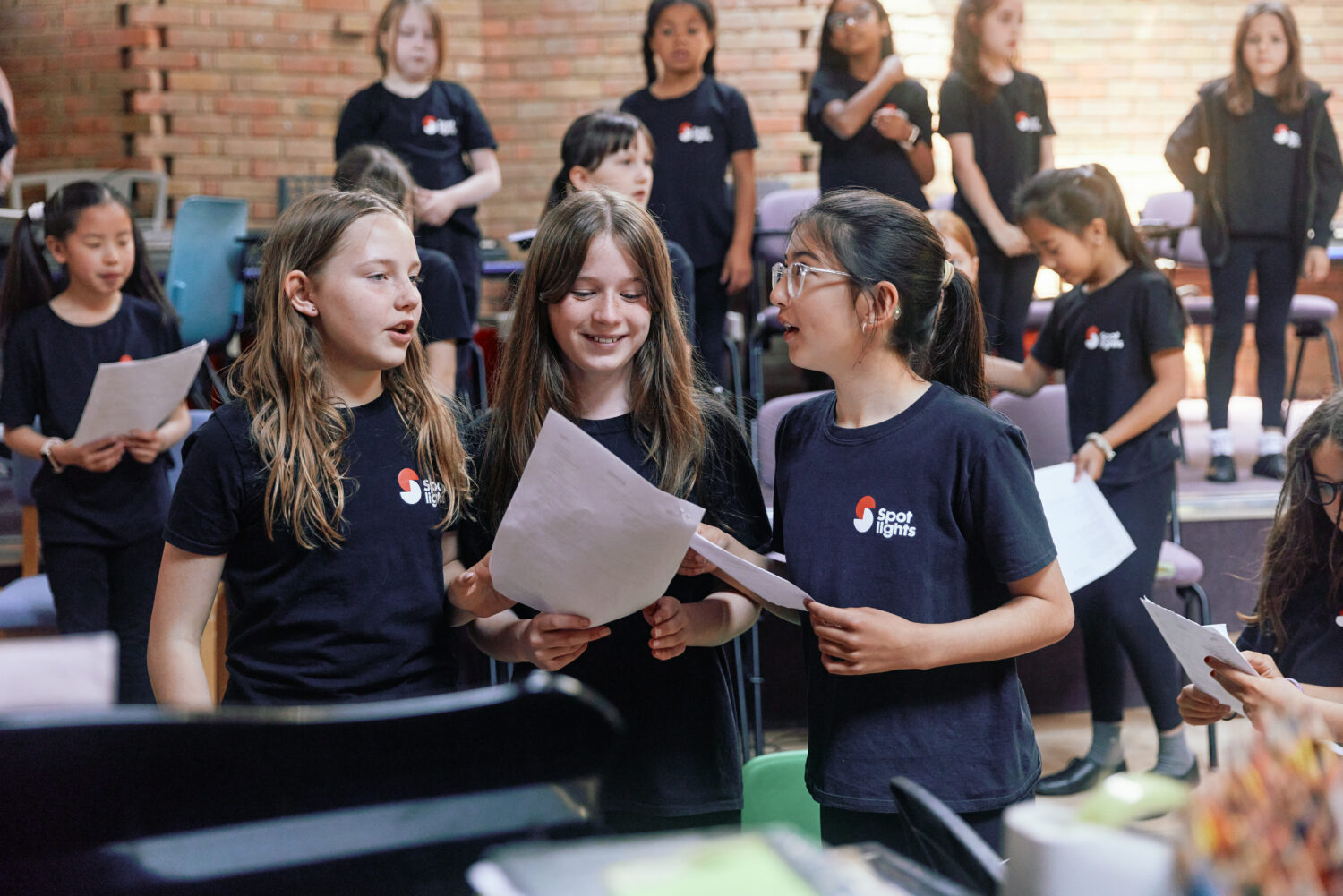 Spotlight children singing at piano